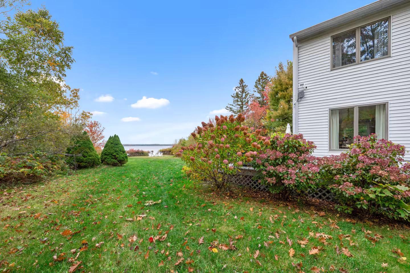 Eagles Nest exterior with autumn hydrangeas, the water beyond
