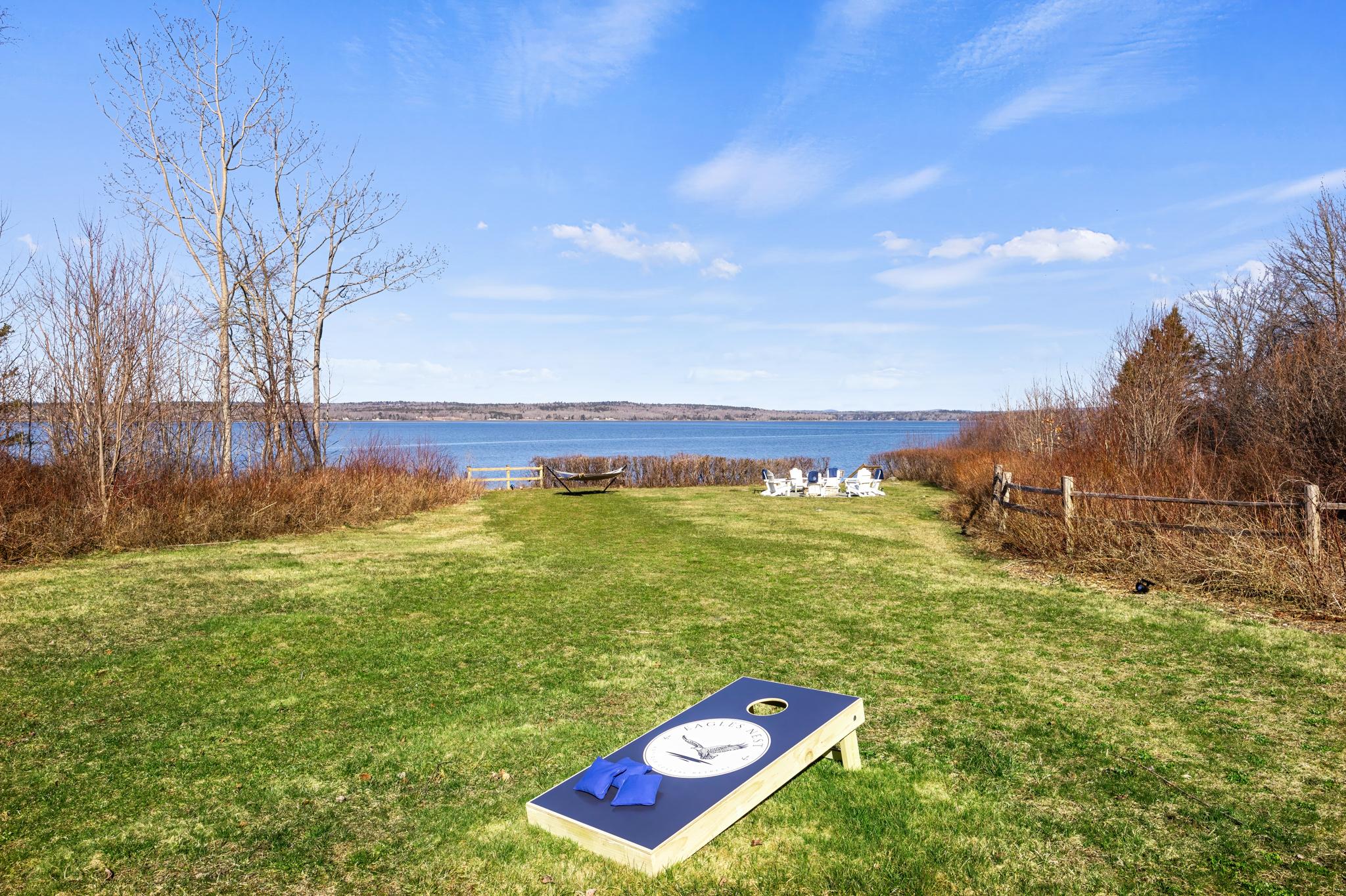 Lawn with custom branded cornhole and bay views at Eagles Nest