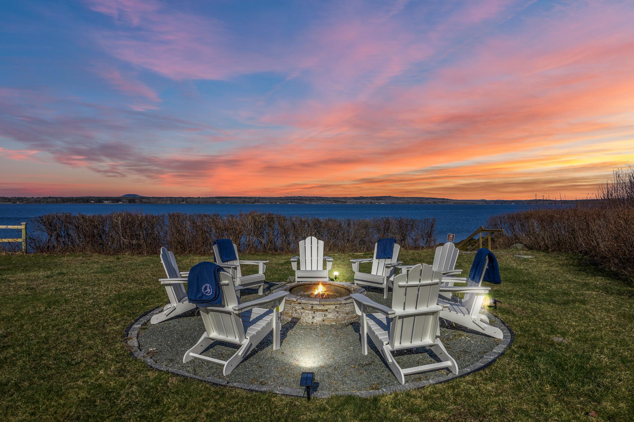 Fire pit lit at sunset on the private rocky shorefront at Eagles Nest