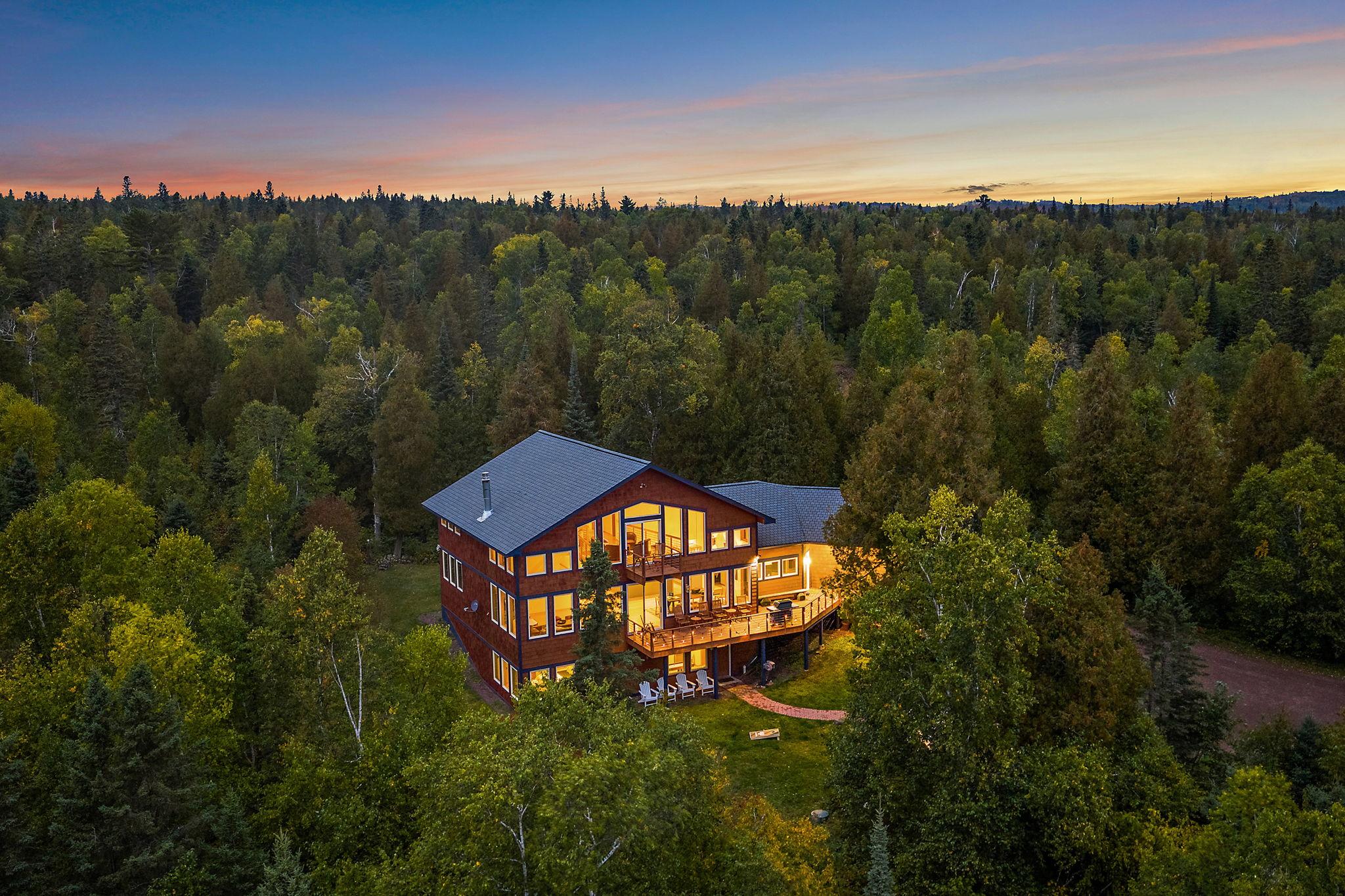 A summer dusk over the lawn and fire pit at Nordhus Lodge