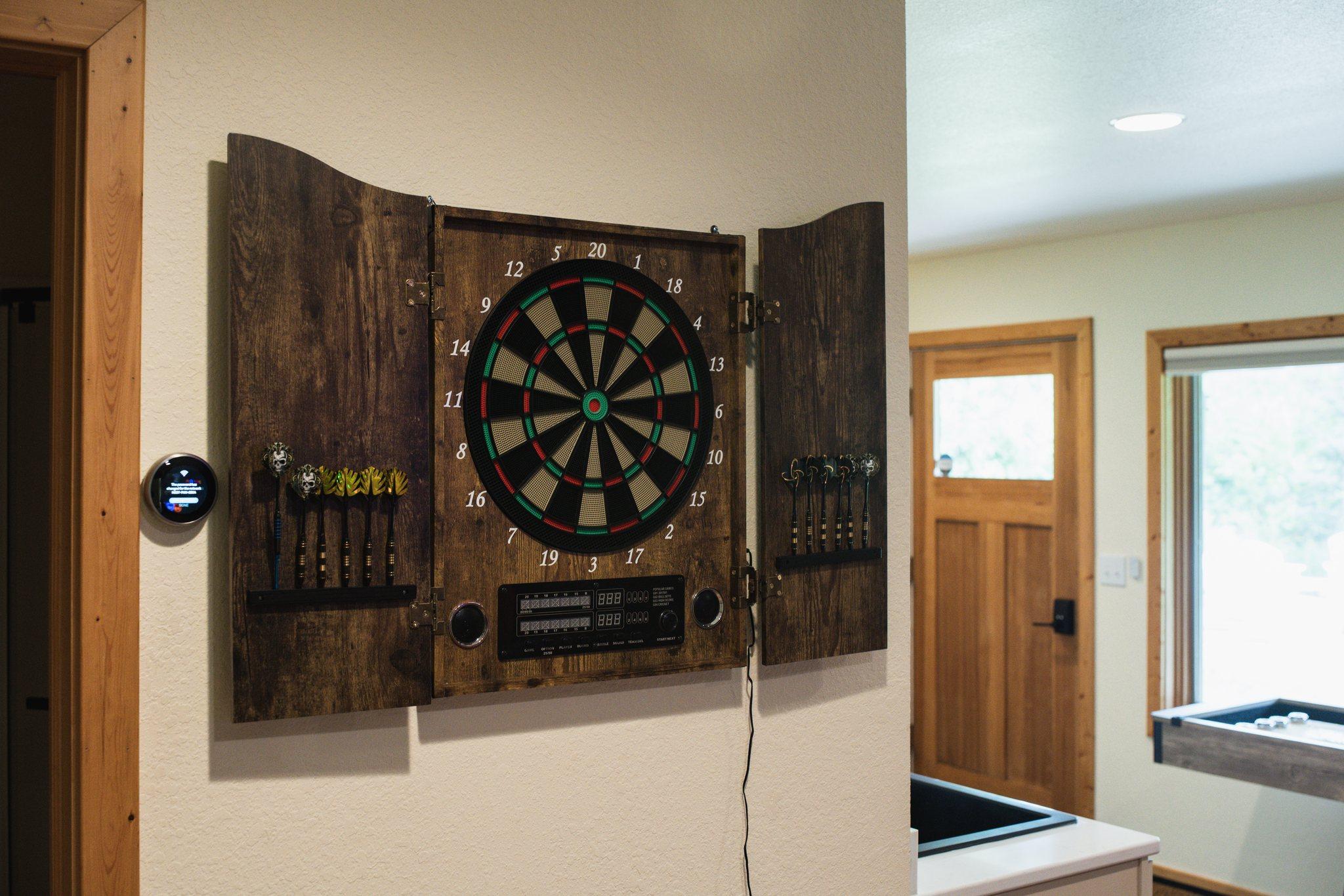 Dart board in a rustic wooden cabinet at Nordhus Lodge