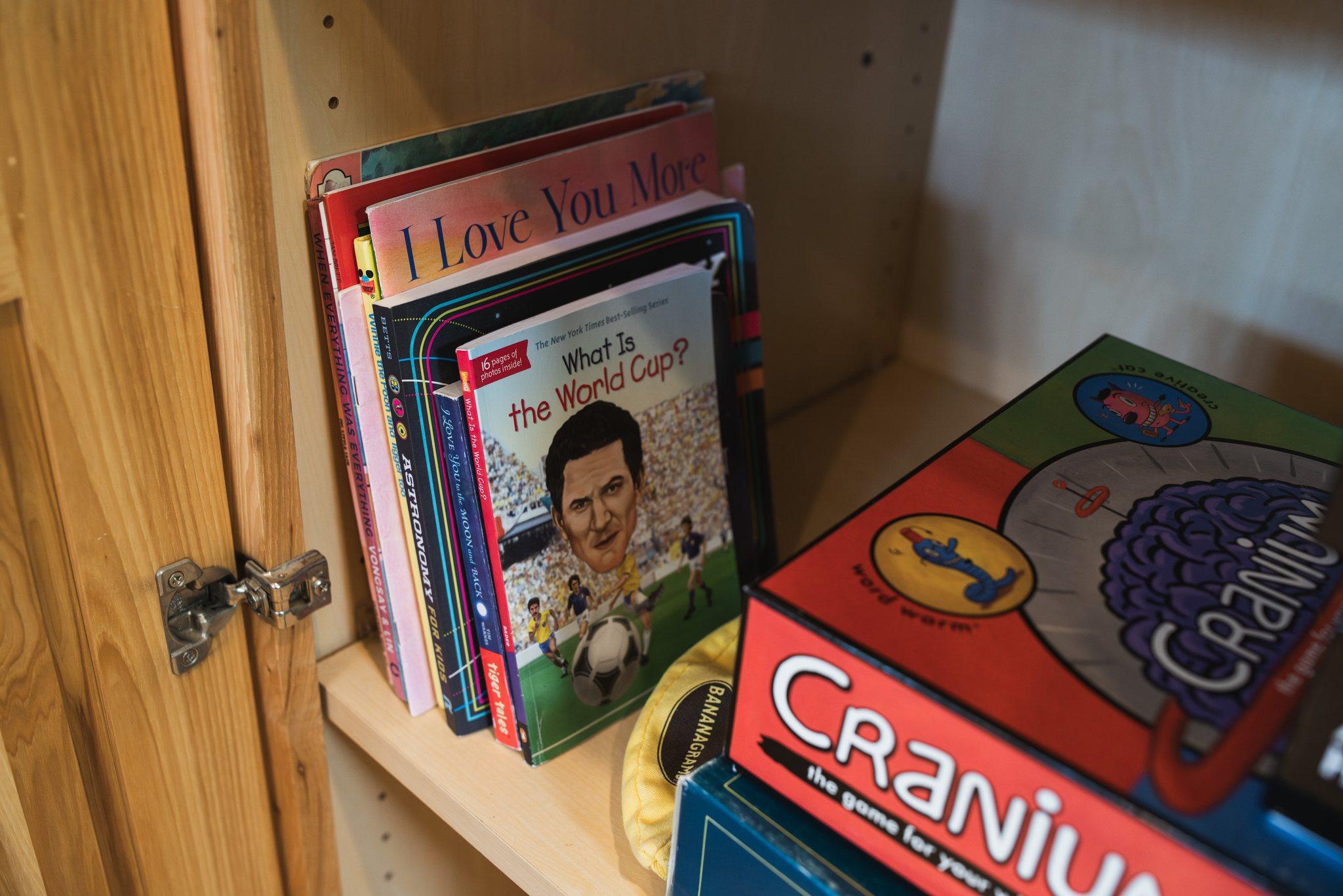Shelf of board games and children's books at Nordhus Lodge