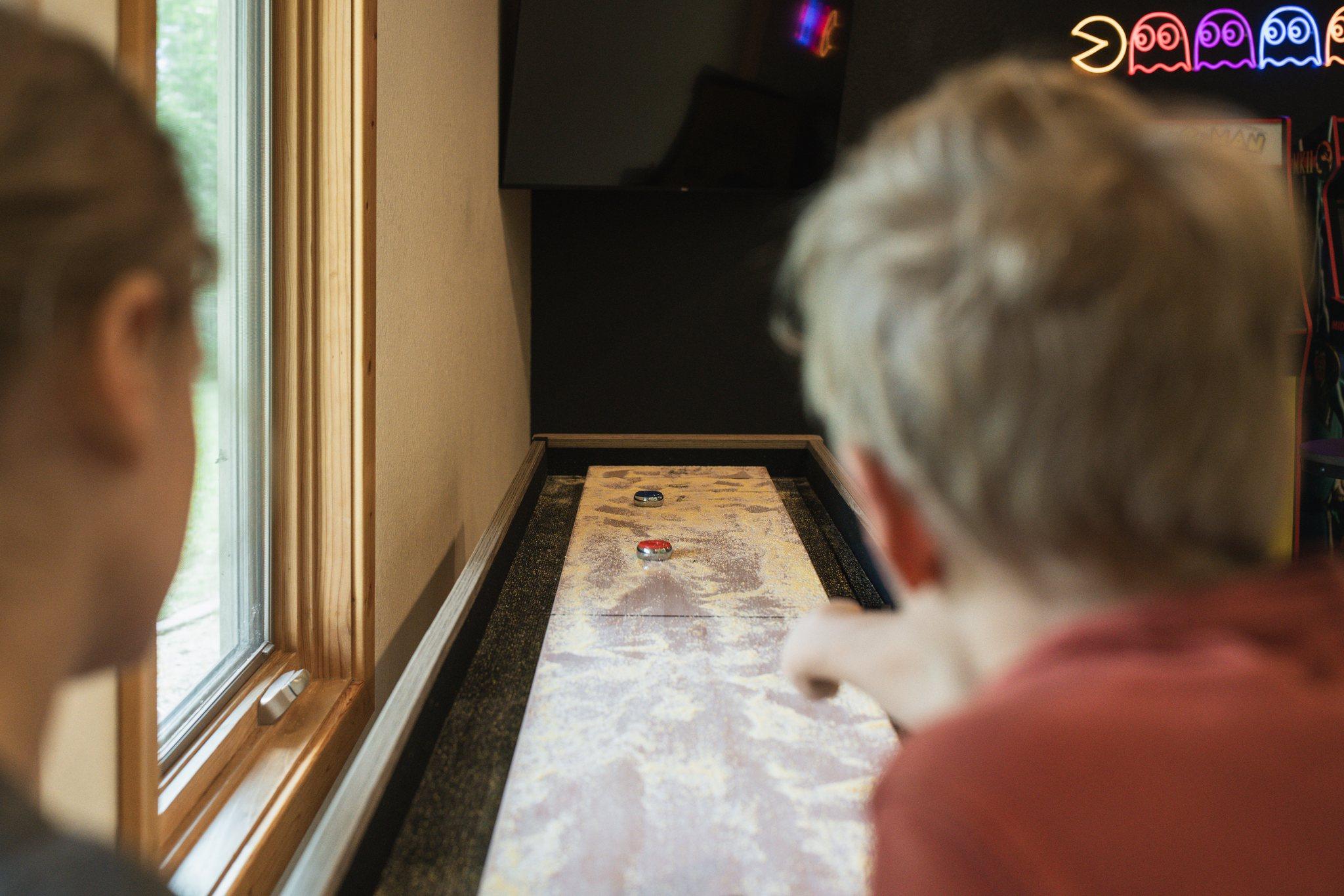 Children playing shuffleboard in the game room at Nordhus Lodge
