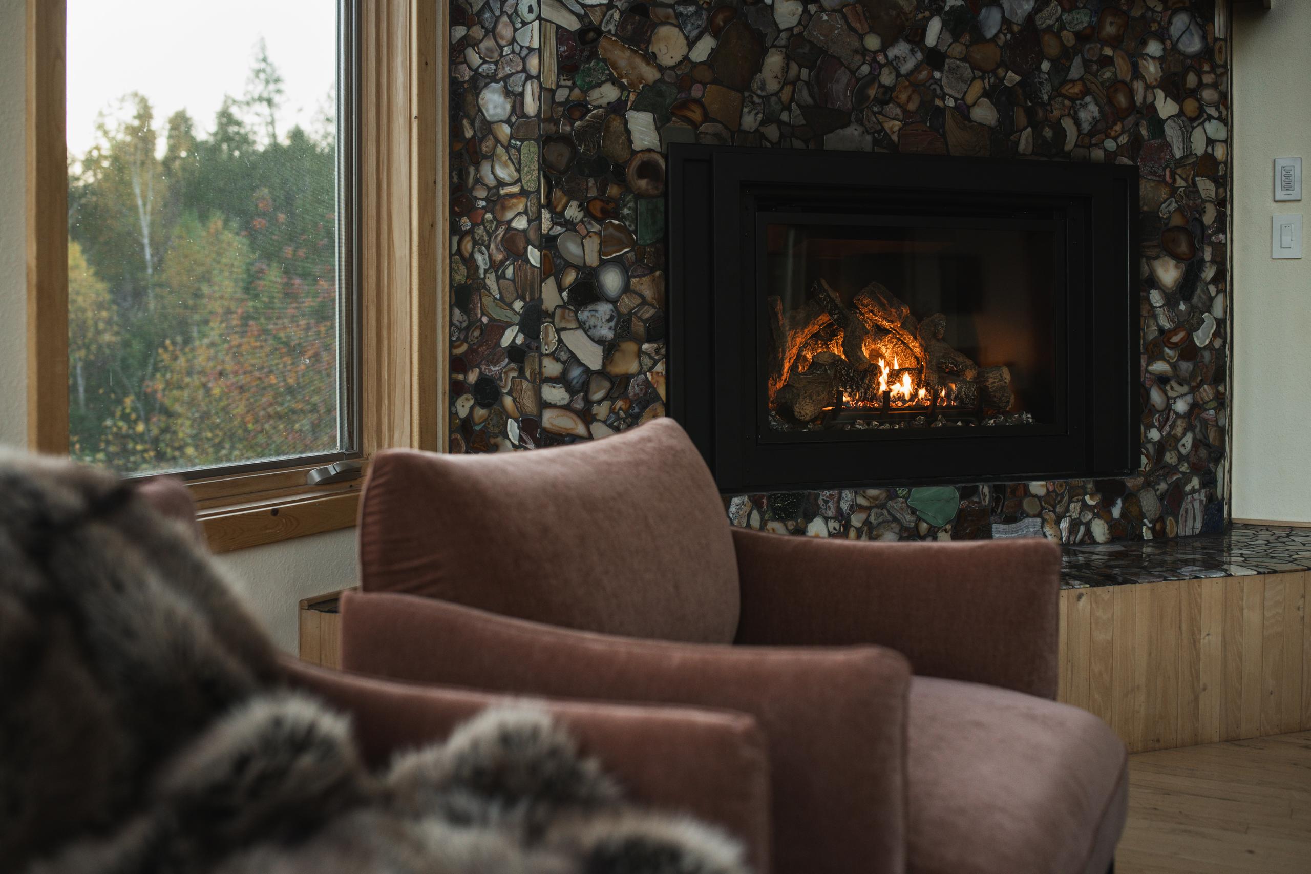 Fireside seating with a fur throw in fall at Nordhus Lodge