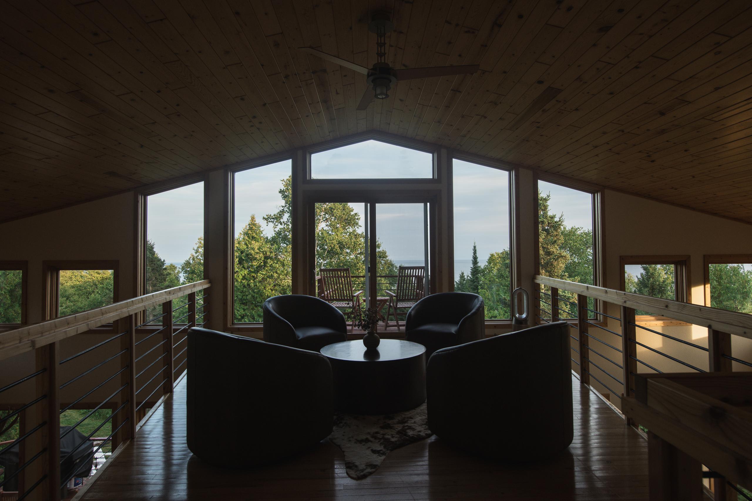Loft gathering space with sunset views over Lake Superior at Nordhus Lodge