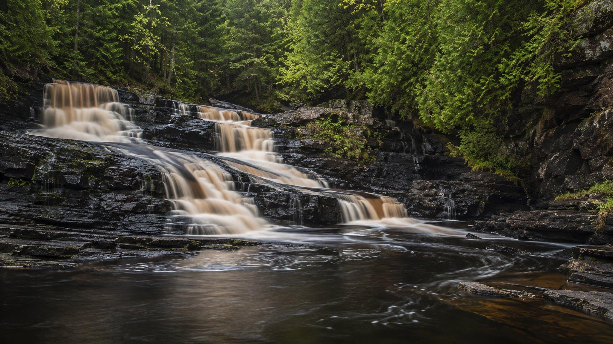 A North Shore river dropping over basalt ledges in the forest