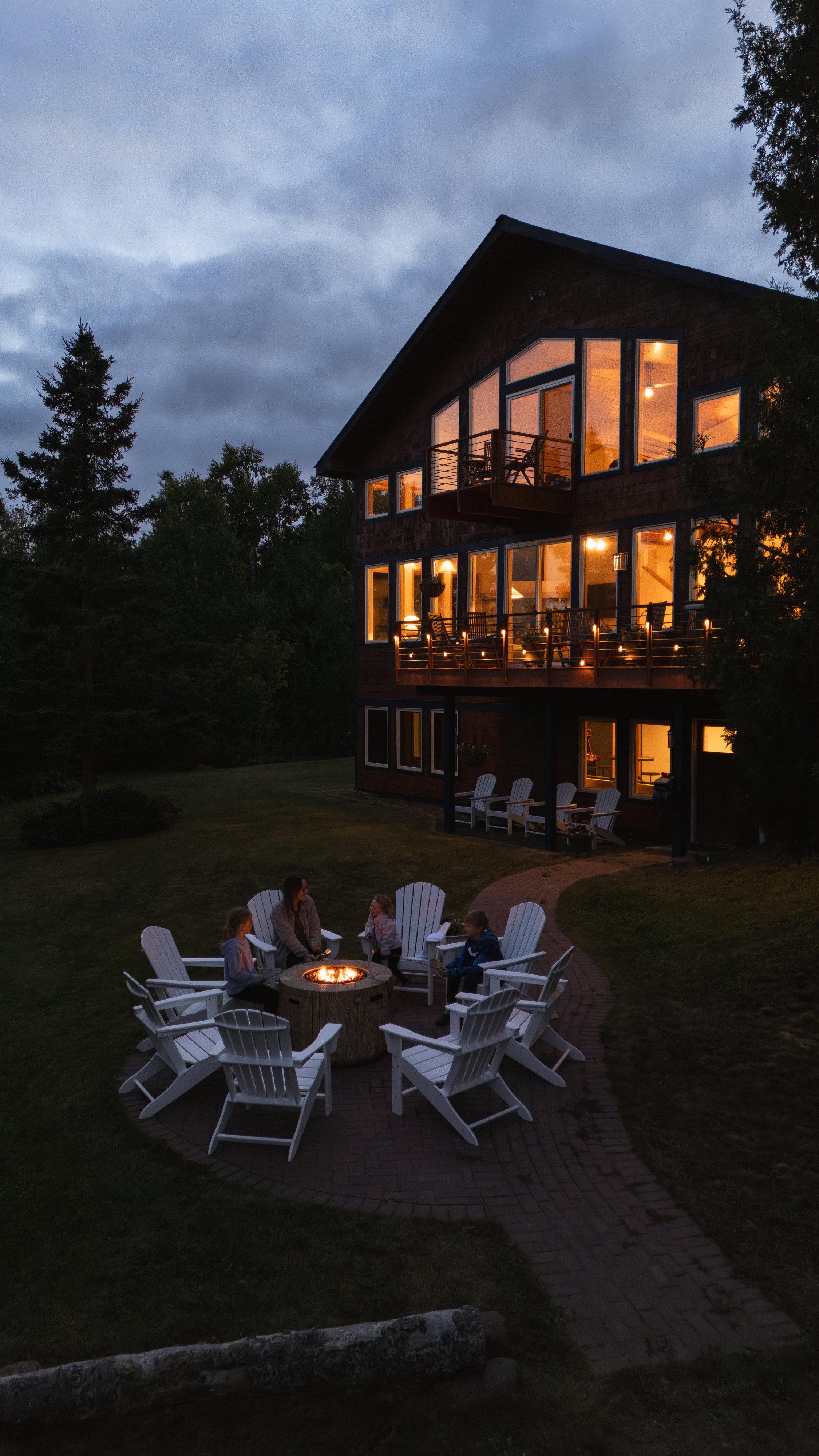 Nordhus Lodge and fire pit glowing under a North Shore twilight sky